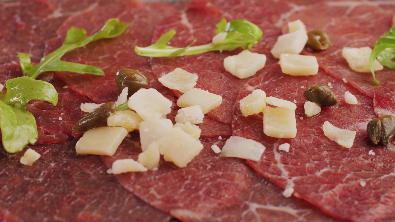 Preparazione del Carpaccio di Manzo con Parmigiano Reggiano, Rucola e Capperi