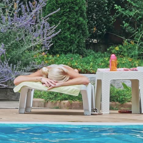 una joven sensual relajándose cerca de la piscina.