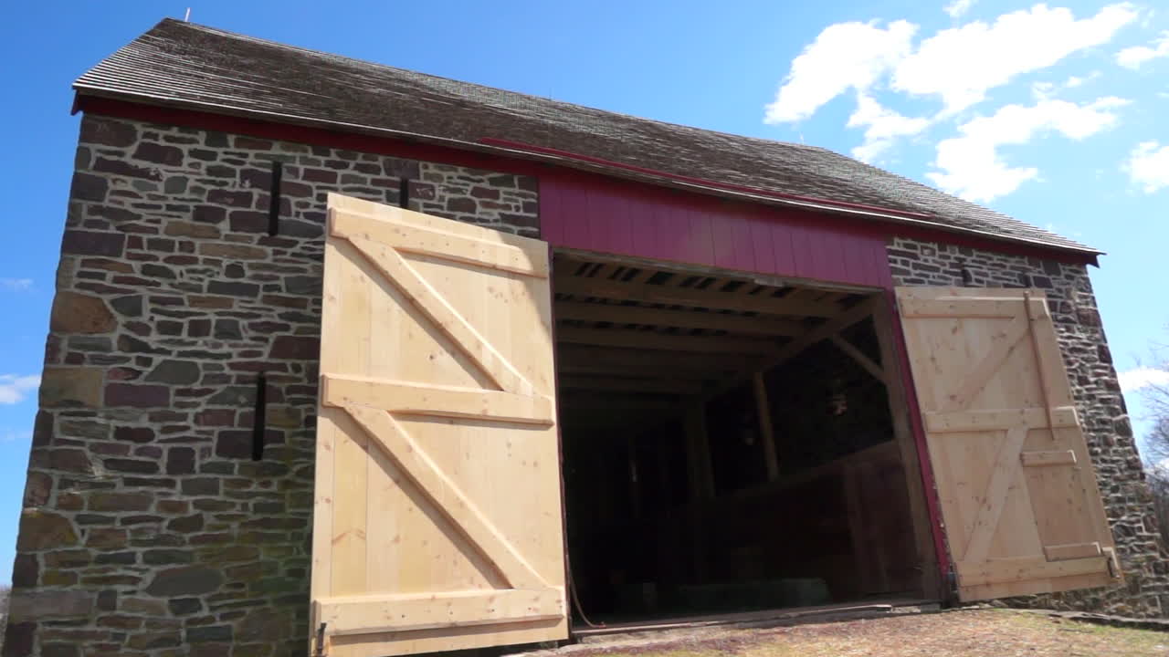 An eighteenth century barn with its doors open.