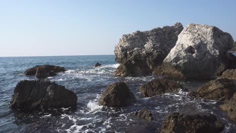 steady shot of big rocks in the sea in sunny warm day - montenegro