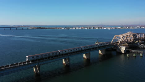 an aerial shot of an nyc subway on an elevated track in queens, ny