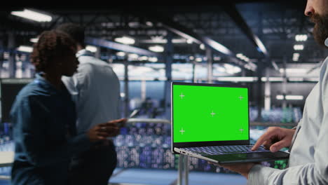 close up of data center employee doing maintenance tasks on green screen laptop