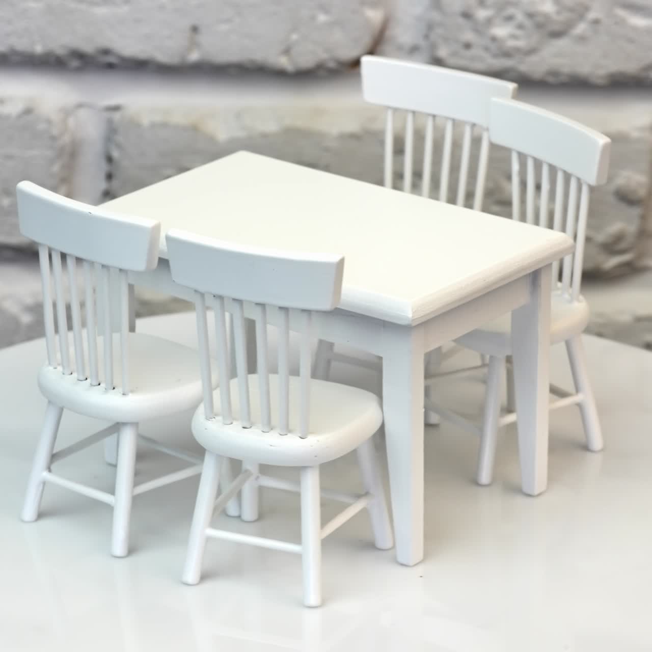 Small miniature table with chairs for dollhouse. White tiny wooden toy furniture