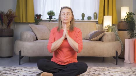 una mujer meditando mirando a la cámara.