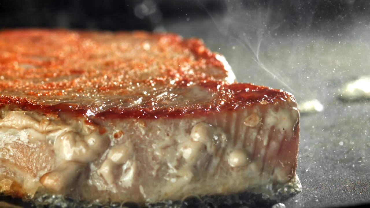 Close-up of Steak Sizzling and Frying on a Hot Pan