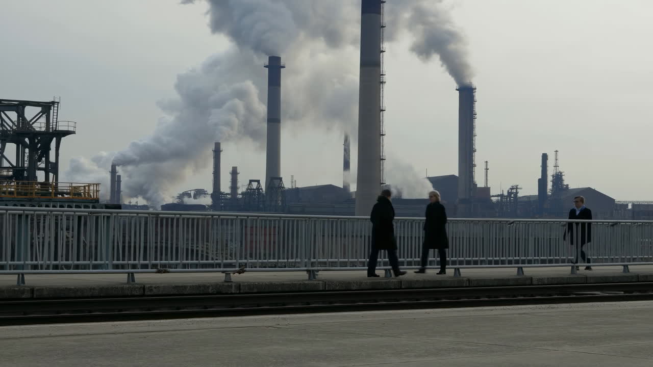 Industrial Skyline With Smoking Chimneys, Commuters On Bridge, Cold Overcast Mood, Silhouettes Spaced