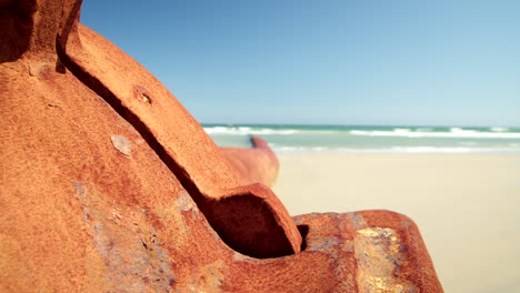 gran tubo oxidado se sienta barnacled en la playa