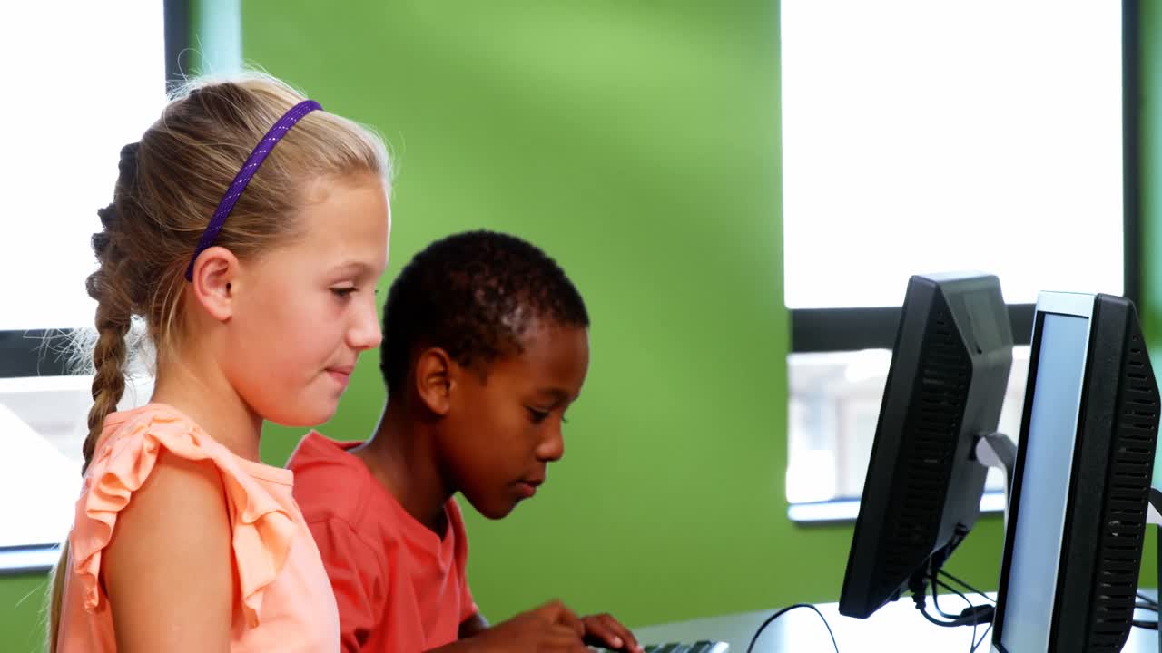 School kids using computer in classroom