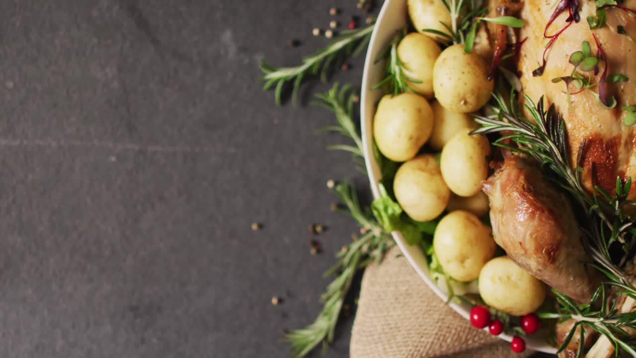 video de una bandeja con pavo asado, patatas y pimienta en superficie gris