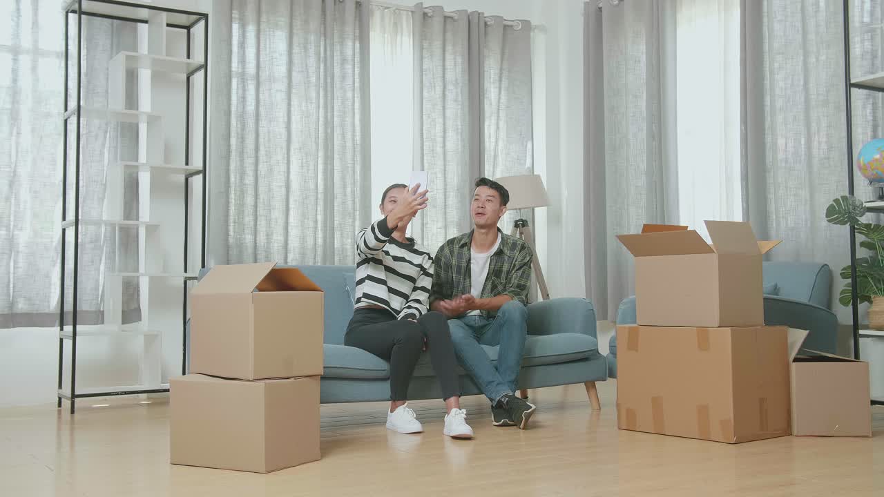 pareja tomando una selfie mientras se mudan a una nueva casa