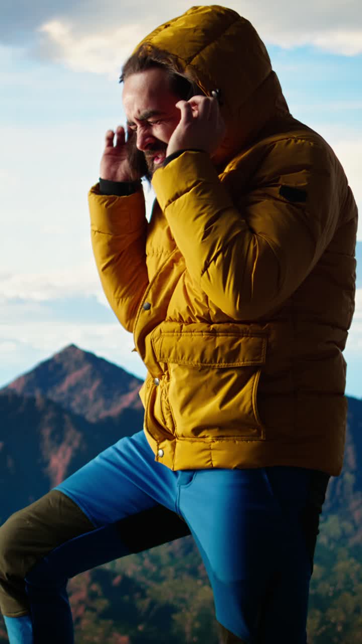 Uomo che trema e cerca di riscaldarsi con il freddo di montagna