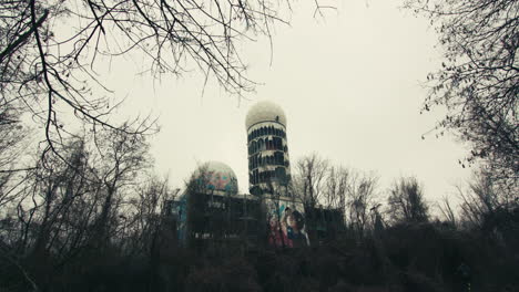 an abandoned building in a forest of bare trees