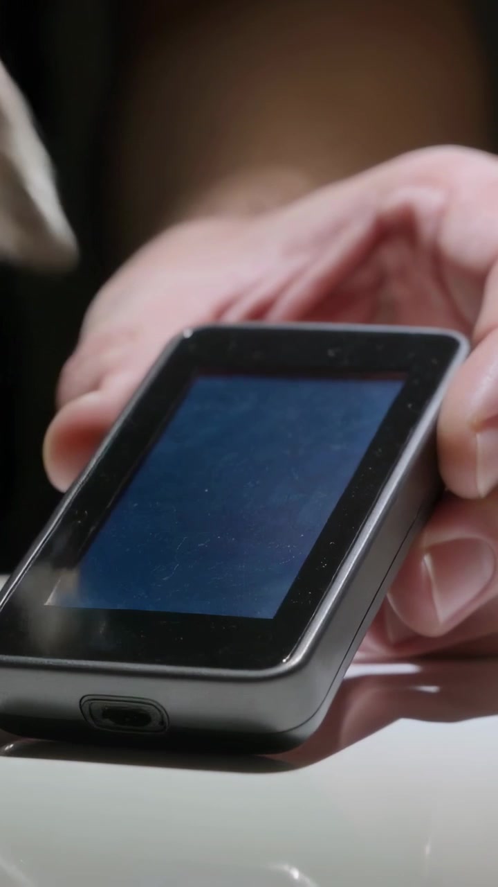 Vertical video: Pressing cloth, pair of hands wiping device screen on home desk removing smudges