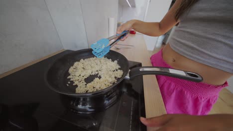 person cooking food in a frying pan