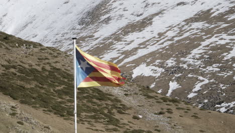 Clip-De-4k-De-Un-Primer-Plano-De-La-Estrellada-Bandera-De-La-Independencia-De-Cataluña-Estelada-Ondeando-Con-El-Viento-En-Los-Campos-En-La-Cima-De-Una-Montaña-Nevada-En-Invierno-En-España