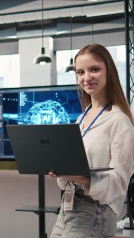 vertical video portrait of young smiling female programmer in office automating with ai