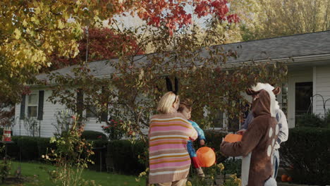 children in festive costumes go for candy on halloween day