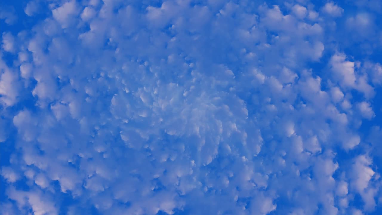 파란 하늘에 있는  구름들이 하늘이나 터널처럼 중심에서 모든 방향으로 움직이고 창하고 있다.
