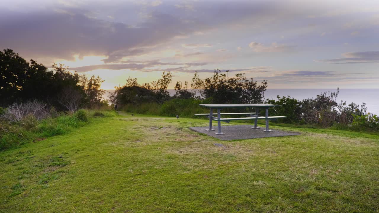 pradera verde con mesa de picnic - vista panorámica de la cabeza de la media luna durante el amanecer - sydney, nsw, australia