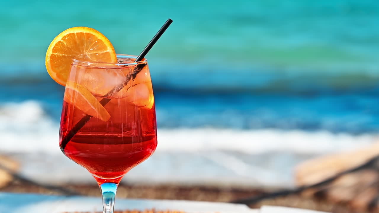 Cocktail con ghiaccio, fetta d'arancia, Mar Egeo sullo sfondo, Grecia. Rallentatore