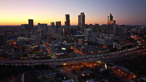 Atlanta-Aerial-v803-establishing-hyperlpase-shot-capturing-busy-freeway-traffic-trails-and-downtown-cityscape-at-rush-hours-from-sunset-to-dusk---Shot-with-Mavic-3-Cine---December-2021