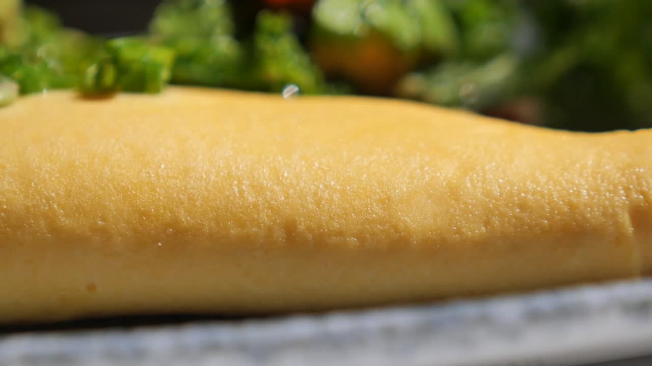 Close-up of a golden omelet with green garnish