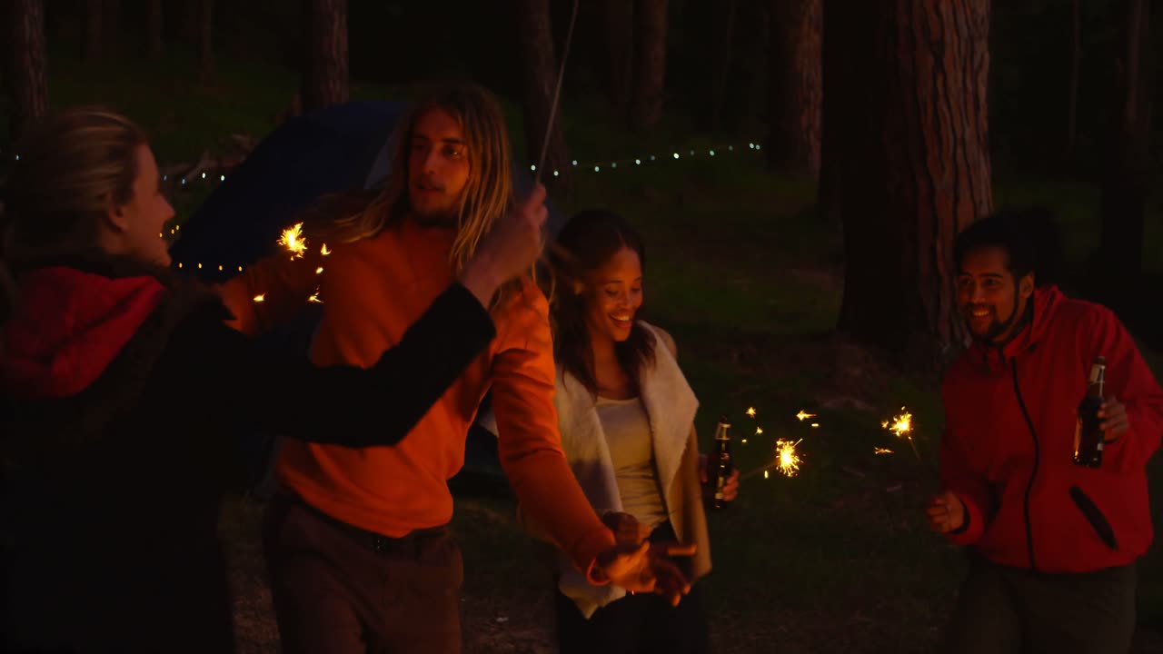 amigos divirtiéndose con chispas en el bosque 4k