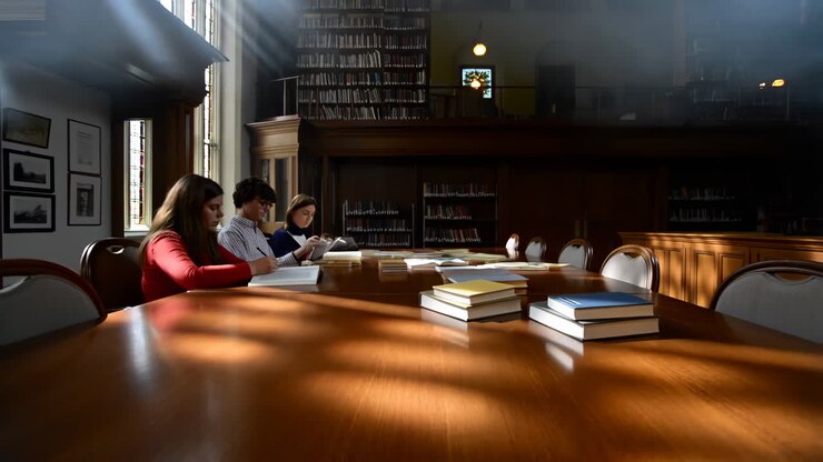 Studenti che studiano in una biblioteca illuminata dal sole