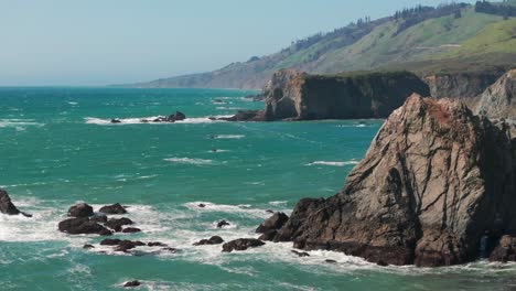 Aerial-drone-shot-flyover-of-a-windy-day-with-large-waves-hitting-the-rocks