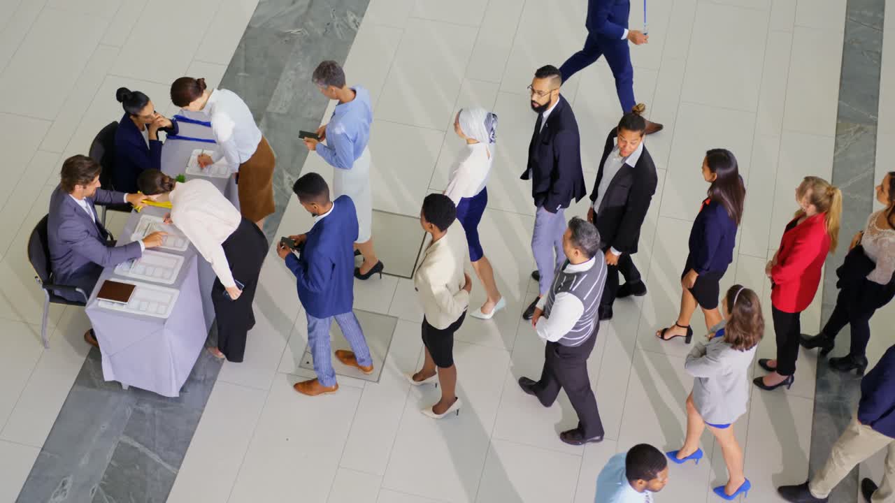 Business people checking in at conference registration table 4k
