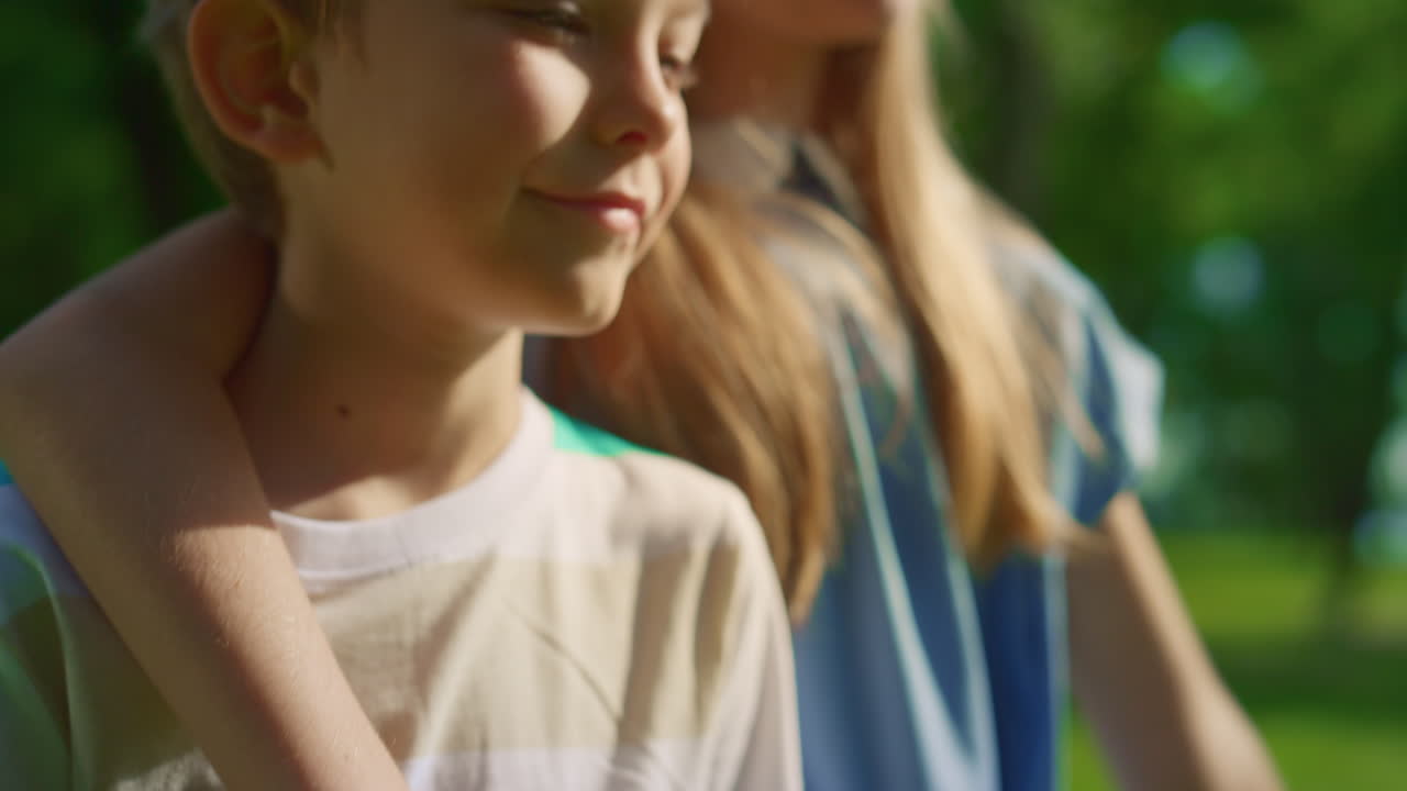 가까이에서 귀여운 여동생이 남동생을 안아주고 있다. 소년은 나무 배드민턴 라켓에 기대어