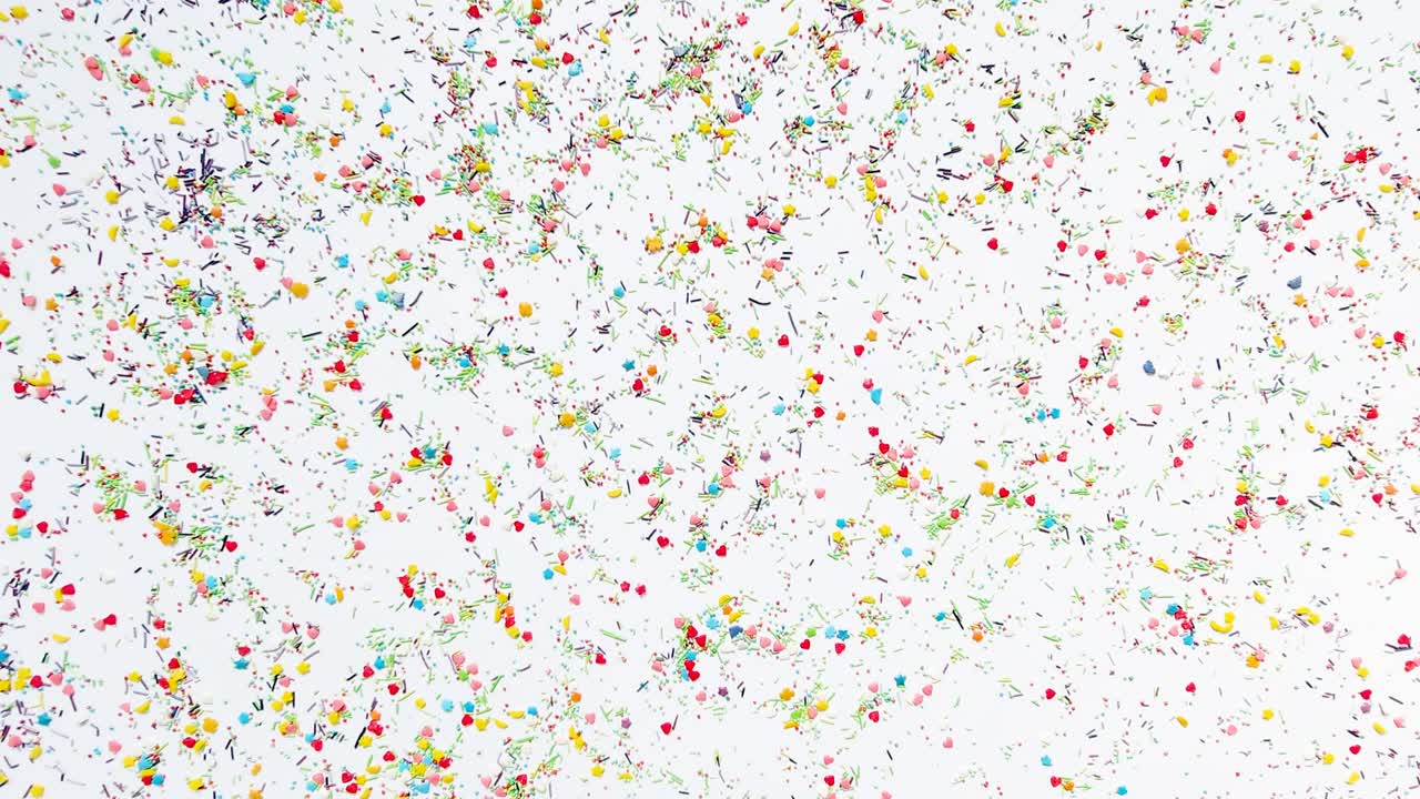 손은 베이킹 스프링클의 배경에 새겨진 글자를 위해 둥근 프레임을 만니다. 타임 스 비디오, 16x9 형식.