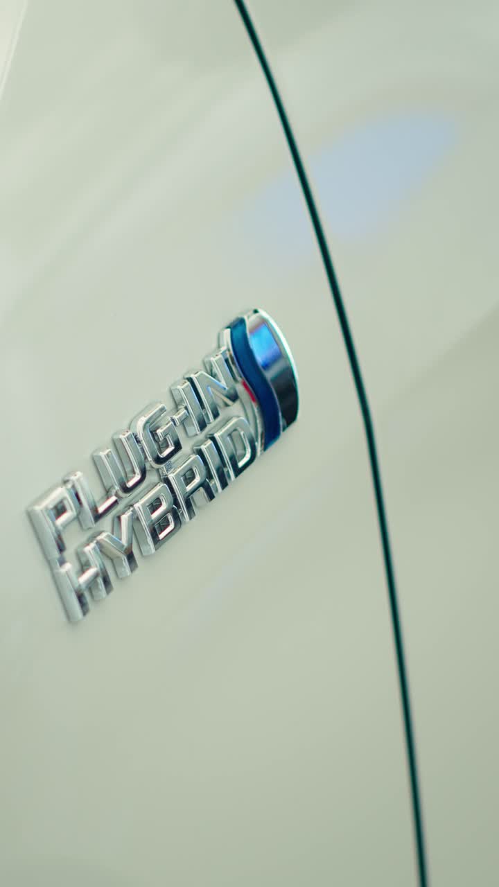 Close-up van een plug-in hybride-embleem op een witte auto