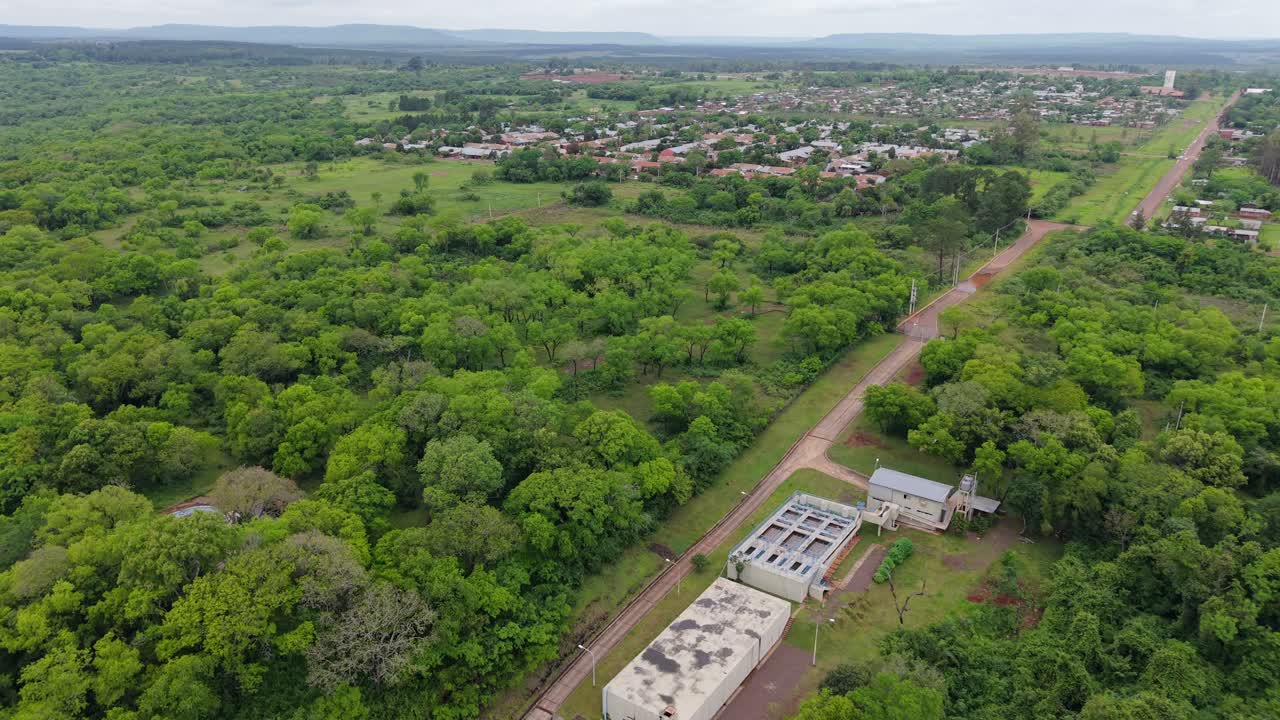 Aerial view of water treatment plant in Misiones, Argentina, surrounded by lush green forest and rural town