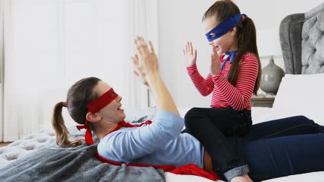 Mother-playing-clapping-game-with-daughter-on-bed-4k