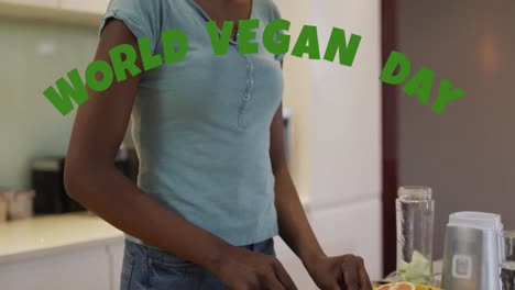 animation of world vegan day text over african american woman cutting vegetables