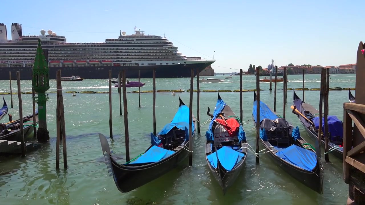 Gondole ormeggiate a Venezia con una grande nave da crociera sullo sfondo