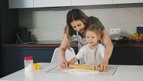 Mutter-Und-Kleine-Tochter-Rollen-Teig-Am-Tisch-In-Der-Küche