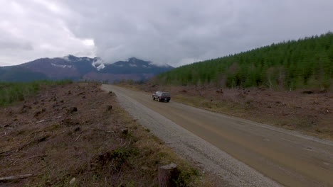 Beautiful-aerial-of-a-4WD-truck-driving-through-the-Cascades-Wilderness-in-Washington-USA