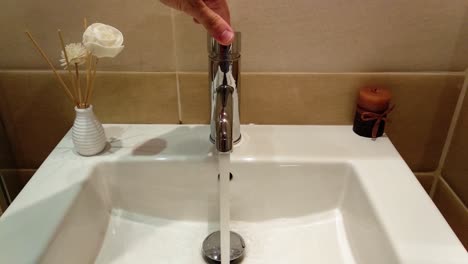 running water from luxury bathroom white sink in hotel room