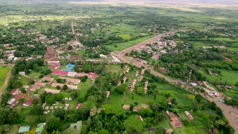 Aerial-view-passing-over-the-rural-town-in-Africa,-in-the-tropical-forests-of-Kenya,-in-Africa---slow,-drone-shot