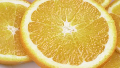 primer plano de naranja valencia fresca en rodajas con fondo blanco enfoque superficial y girando lentamente