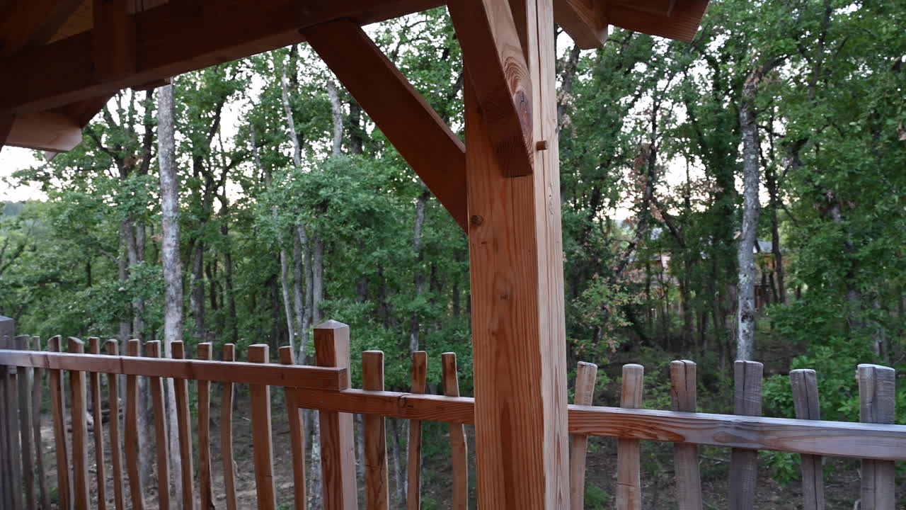 패닝 샷: 프랑스 숲에 자리 잡은 나무 오두막 전망