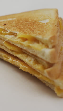 video de primer plano de un sándwich de pan blanco con queso recién preparado sobre un fondo blanco
