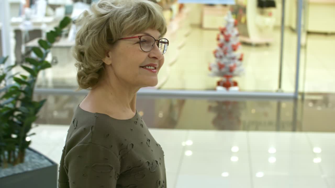 Usmívající se starší žena v nákupním centru.