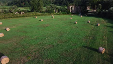 balas de heno en un campo verde cerca del antiguo acueducto romano en montalto, lazio, italia, día soleado, vista aérea