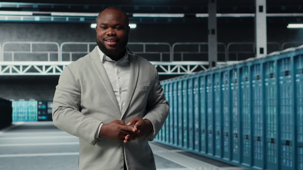 Vertical video Smiling engineer walking in data center facility with rows of supercomputers