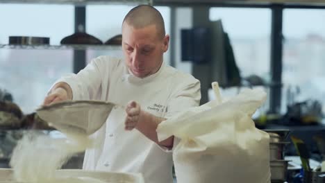 the baker sifts rye flour on bread