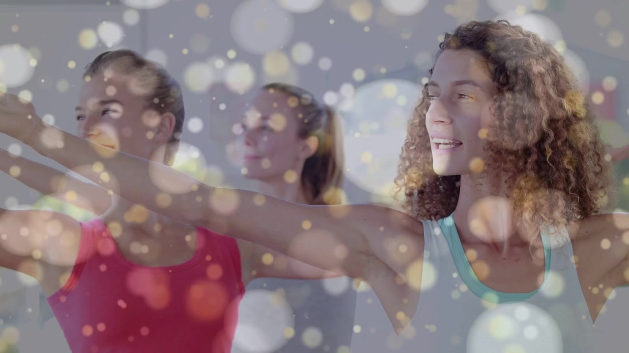 Donna riccia che guida due persone, partendo dalla posizione con i palmi uniti, aprendo le braccia in avanti e ruotando i busti nello yoga, con effetto bokeh.