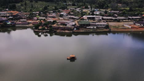 Aerial-rotating-shot-of-tourists-enjoying-a-boat-ride-on-the-lake-at-daytime-in-Ban-Rak-Tai,-Mueang-Mae-Hong-Son,-Thailand